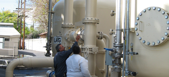 LAWC treatment plant: Lincoln Avenue Water Company (LAWC) workers inspect liquid-phase granular activated carbon tanks at the NASA-funded LAWC Altadena groundwater treatment plant. The LAWC plant is treating groundwater at the furthest reach of groundwater chemicals that originated at the Jet Propulsion Laboratory.